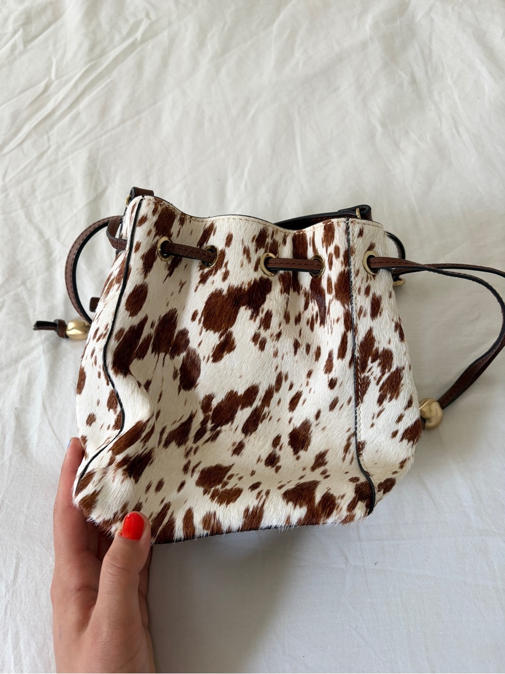 The Mini Drawstring Crossbody Bucket Bag Cow Print - Picture 3 of 11